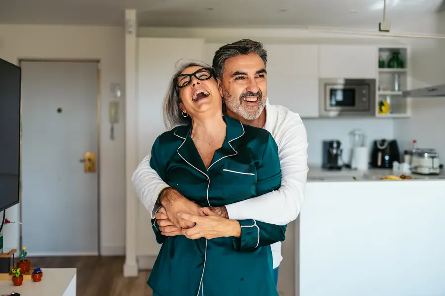 A couple laughing together at home